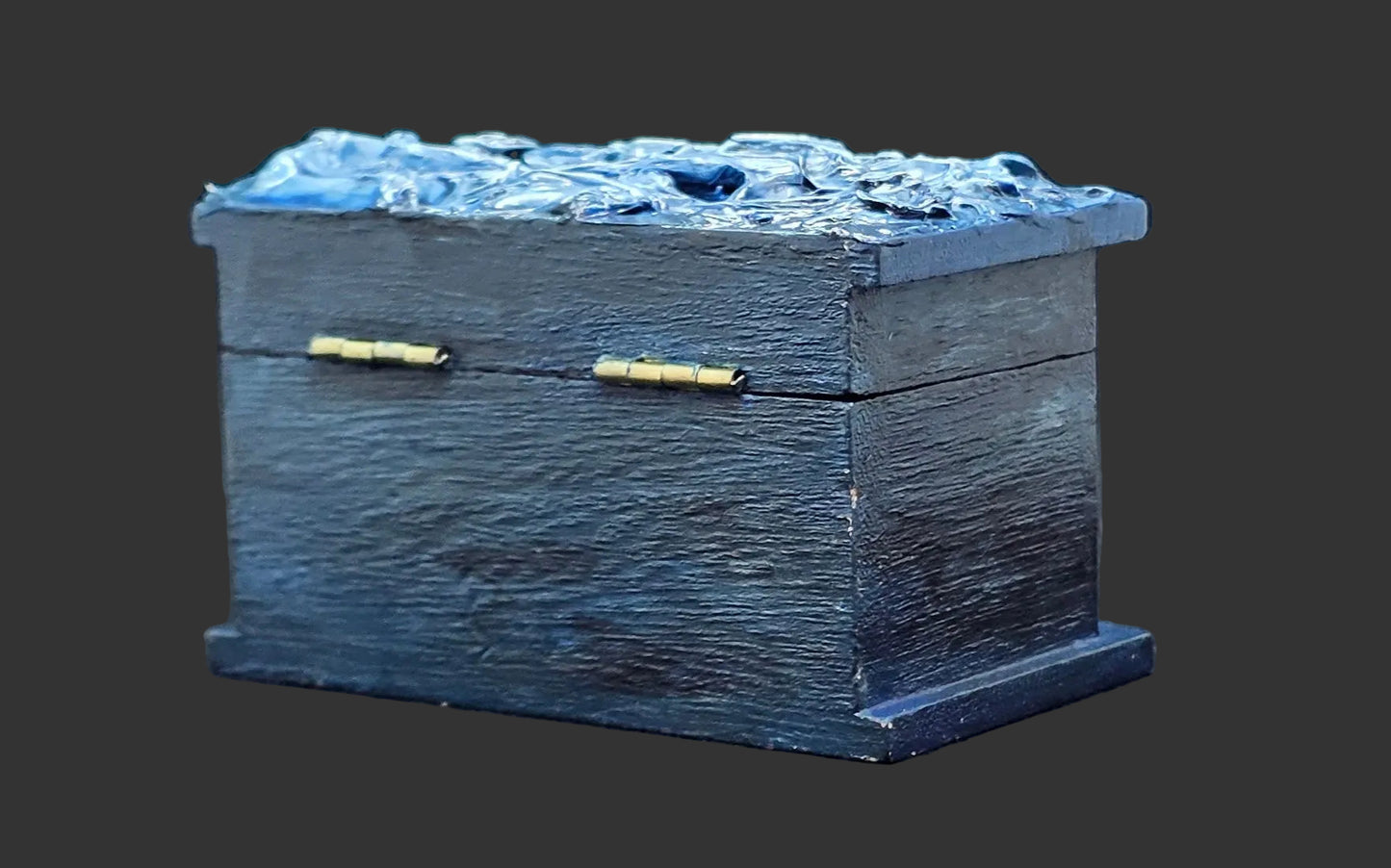 Blue painted wooden box with brass accents on a dark background