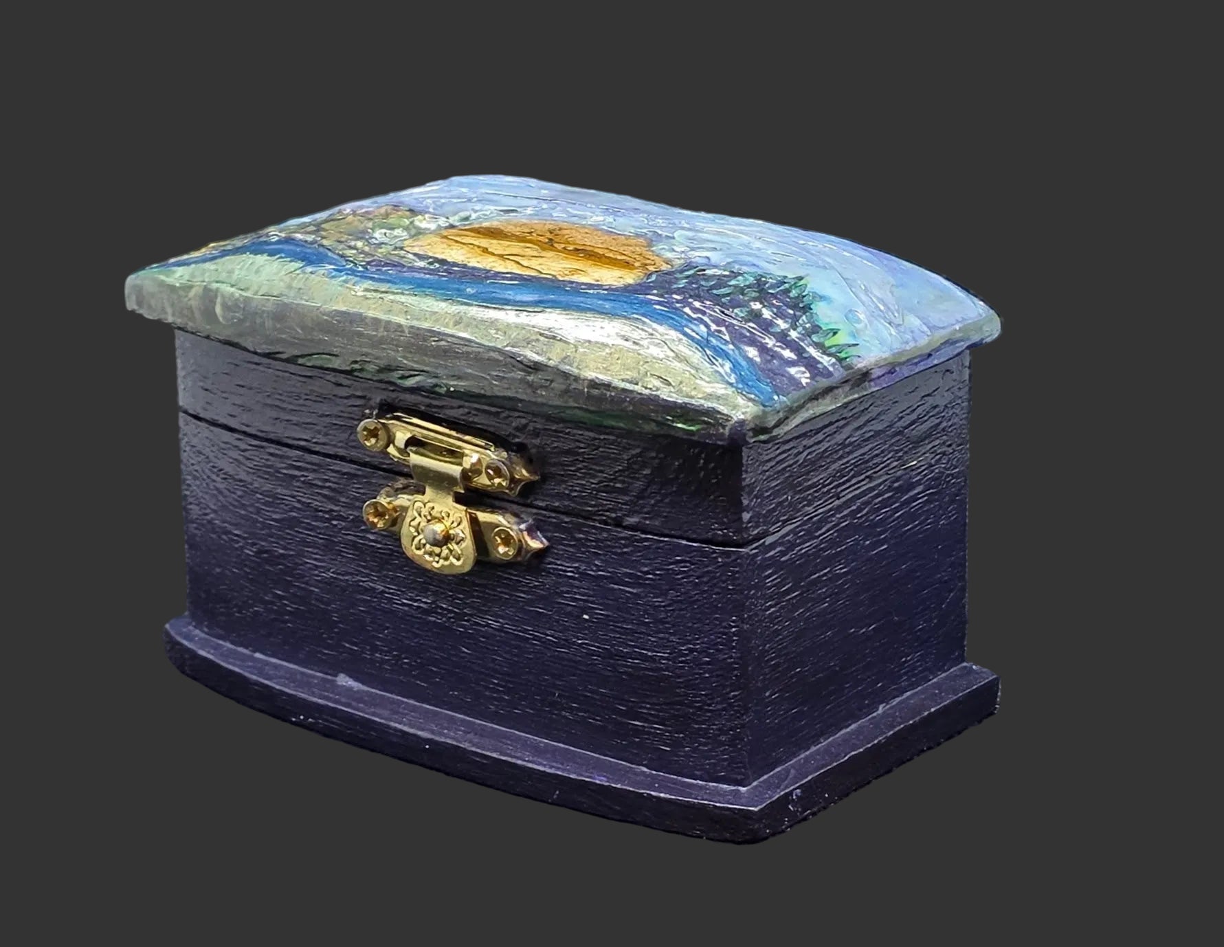 Paintd box with a lid featuring a jasper cabochon and landscape design on a dark background