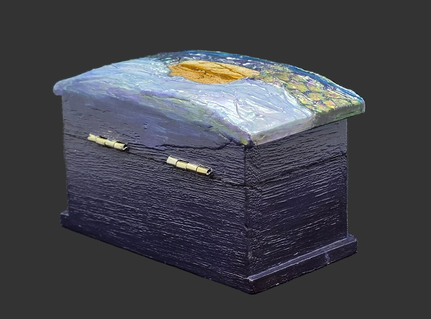 Decorative jewelry box with a painted lid on a dark background