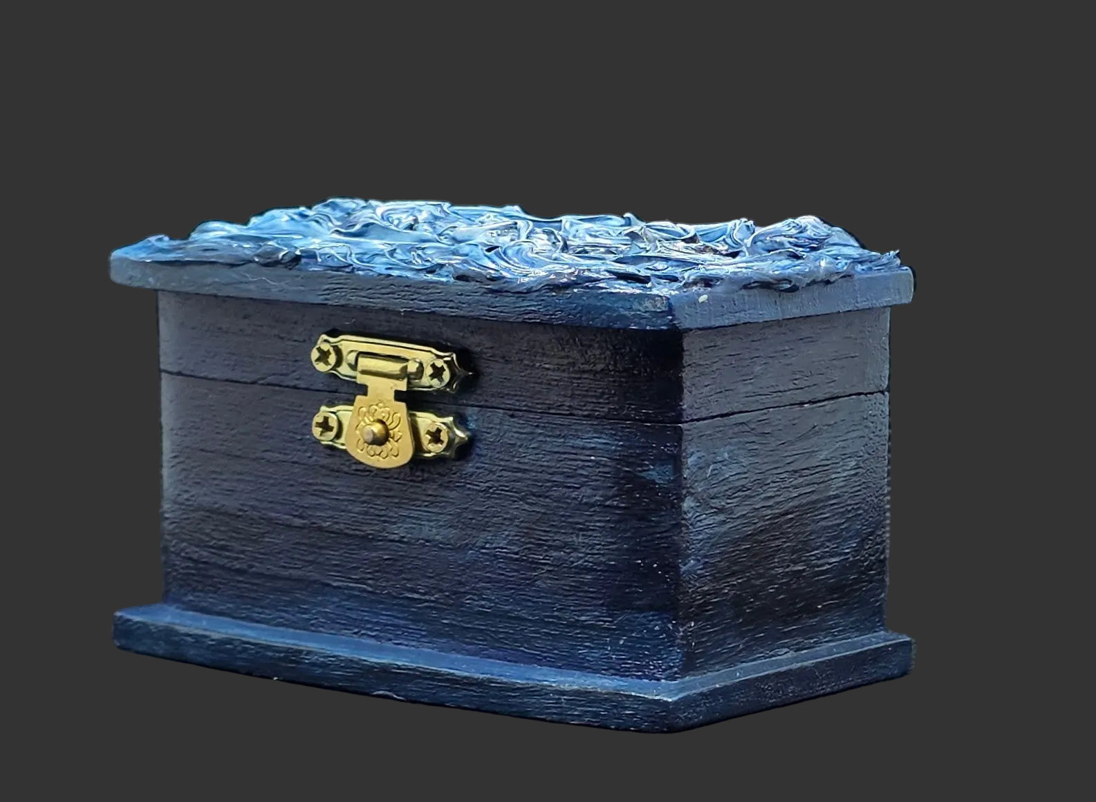 Blue painted wooden box with brass latch on a dark background